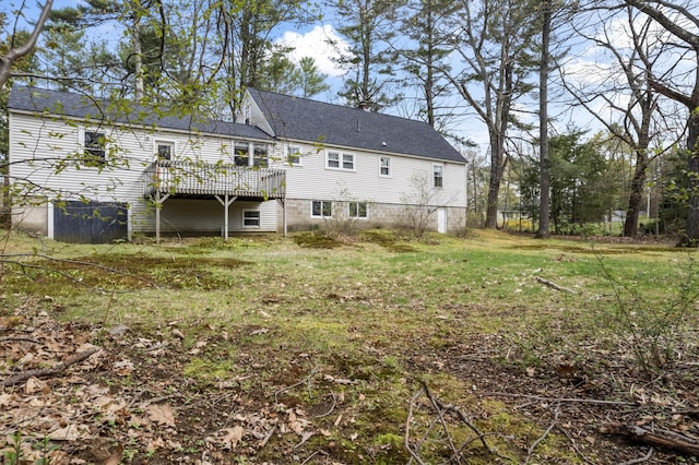rear view of house featuring a deck and a lawn