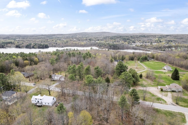 aerial view of property's location with a nearby body of water and a heavily wooded area