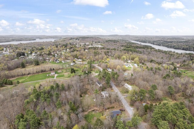 view of property location featuring a nearby body of water and a forest