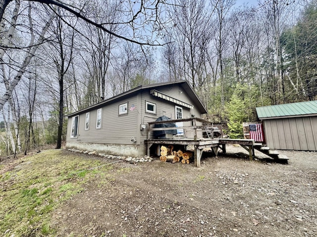 1429 Canada Rd, Moscow, ME 04920 - view of property exterior with a wooden deck and an outbuilding