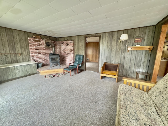 1429 Canada Rd, Moscow, ME 04920 - carpeted living room featuring a wood stove and wooden walls