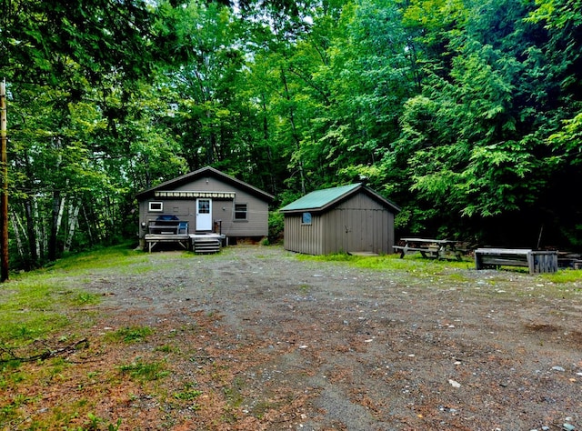 1429 Canada Rd, Moscow, ME 04920 - view of yard with a storage unit, a deck, and a forest view
