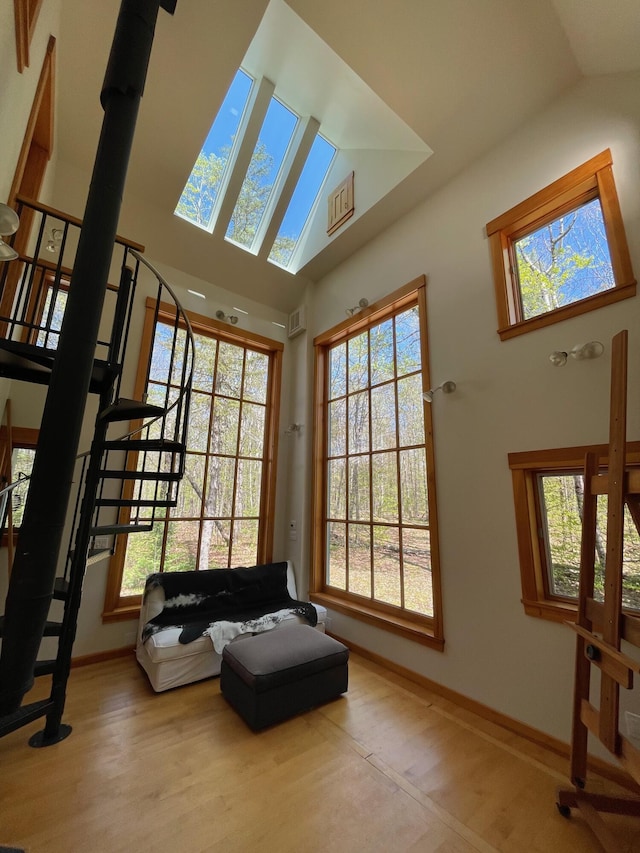 living room with wood finished floors, vaulted ceiling, and baseboards