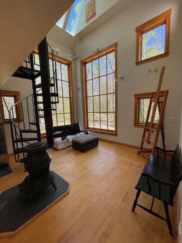 workout room featuring healthy amount of natural light, wood finished floors, and a towering ceiling