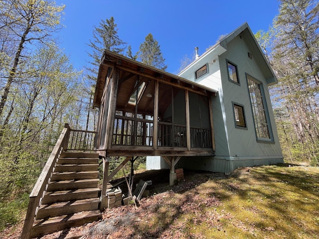 rear view of house with a sunroom and stairway