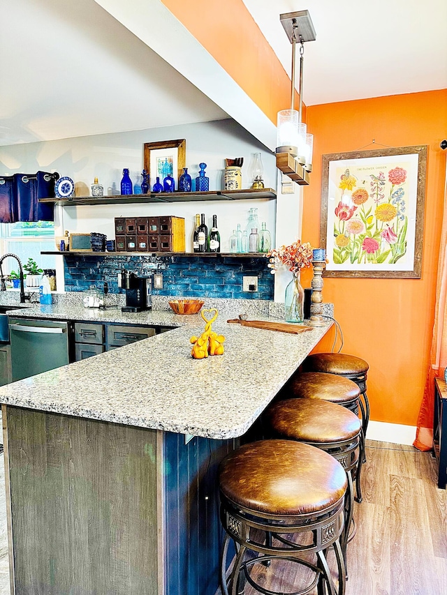 2 High St, Machias, ME 04654 - bar with light wood-style flooring, pendant lighting, stainless steel dishwasher, decorative backsplash, and a sink
