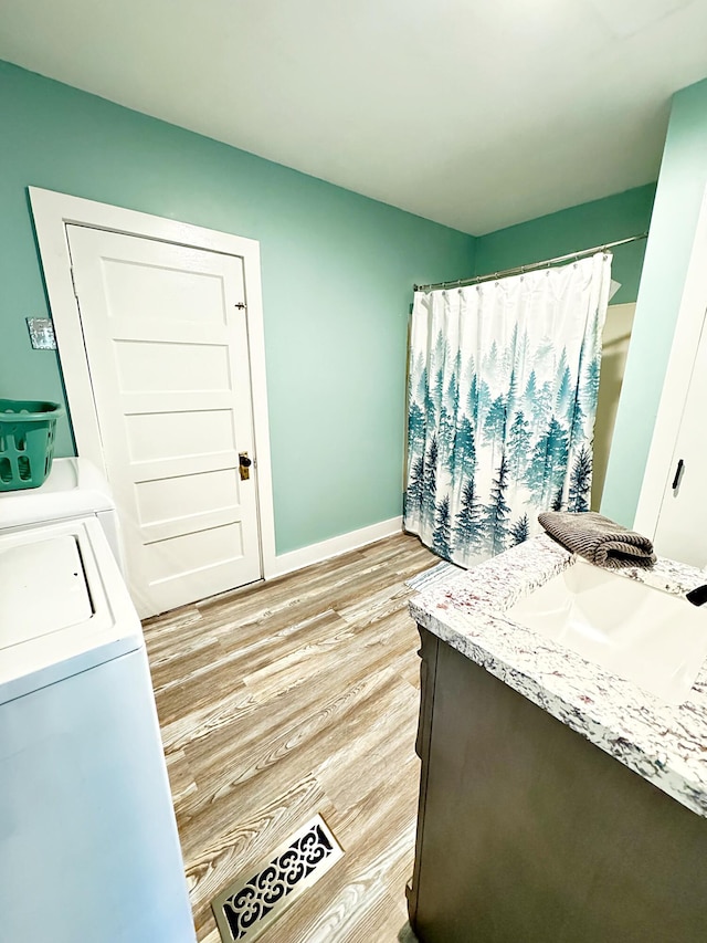 2 High St, Machias, ME 04654 - full bath featuring vanity, wood finished floors, washing machine and clothes dryer, and baseboards