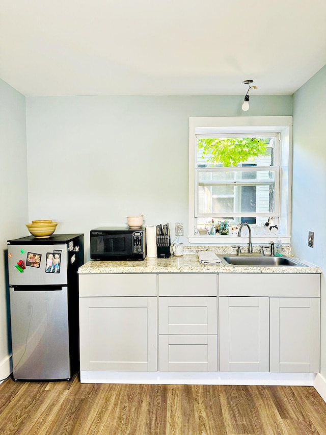 2 High St, Machias, ME 04654 - kitchen with freestanding refrigerator, black microwave, a sink, and light wood-type flooring