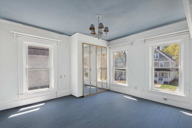 unfurnished dining area with a chandelier, dark wood-style floors, and baseboards