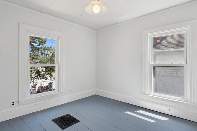 spare room with dark wood finished floors, ornamental molding, and baseboards