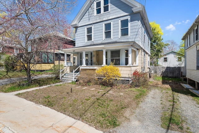 american foursquare style home with a porch and fence