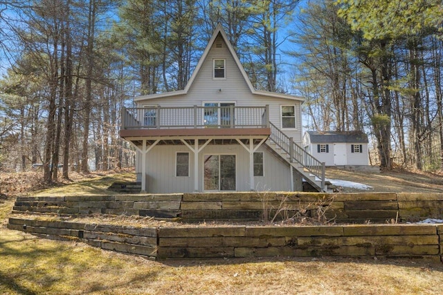 back of property featuring a wooden deck, stairway, an outbuilding, and fence