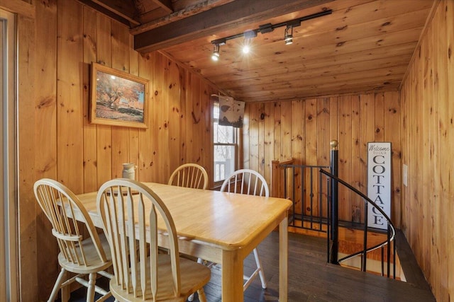 dining space featuring track lighting, wood walls, hardwood / wood-style floors, and wooden ceiling