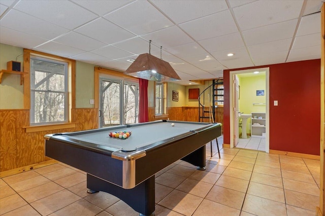 recreation room with a wainscoted wall, a paneled ceiling, billiards table, wood walls, and light tile patterned floors