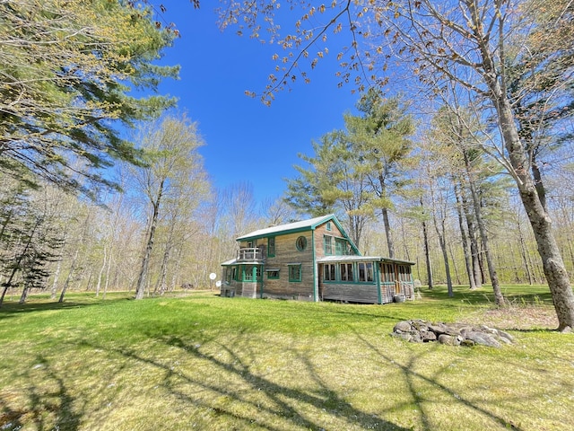 rear view of house with a sunroom and a yard