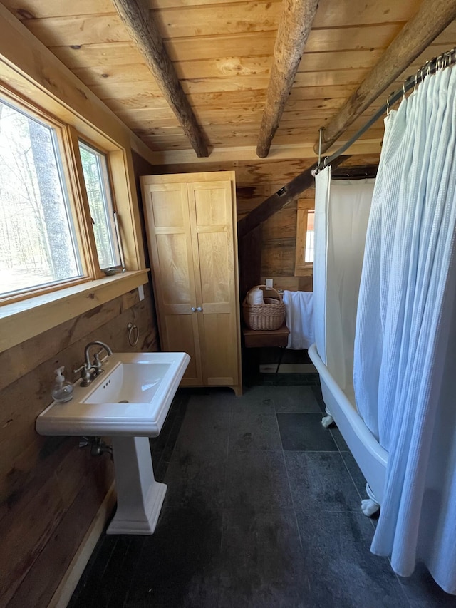 full bathroom with wooden ceiling, wooden walls, beam ceiling, and shower / bath combination with curtain