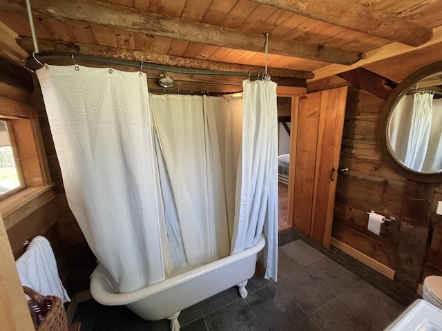 bathroom featuring wooden ceiling, tile patterned floors, beamed ceiling, shower / bath combination with curtain, and toilet