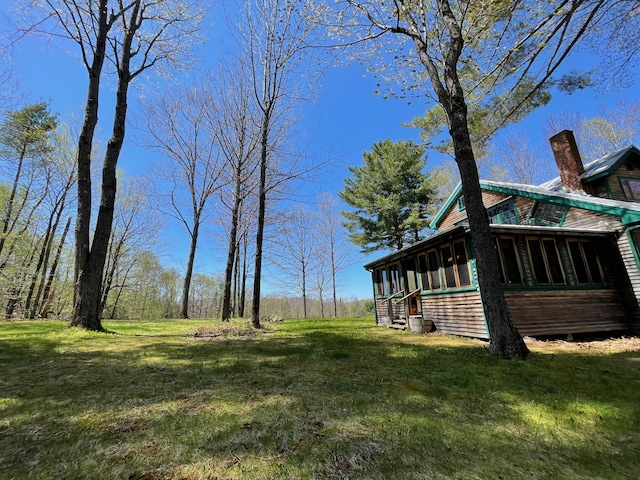 view of grassy yard with a sunroom