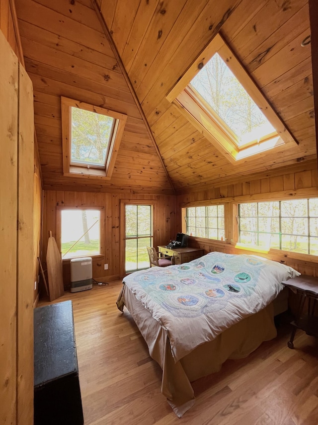 bedroom featuring a skylight, lofted ceiling, wood ceiling, light wood-style flooring, and wood walls