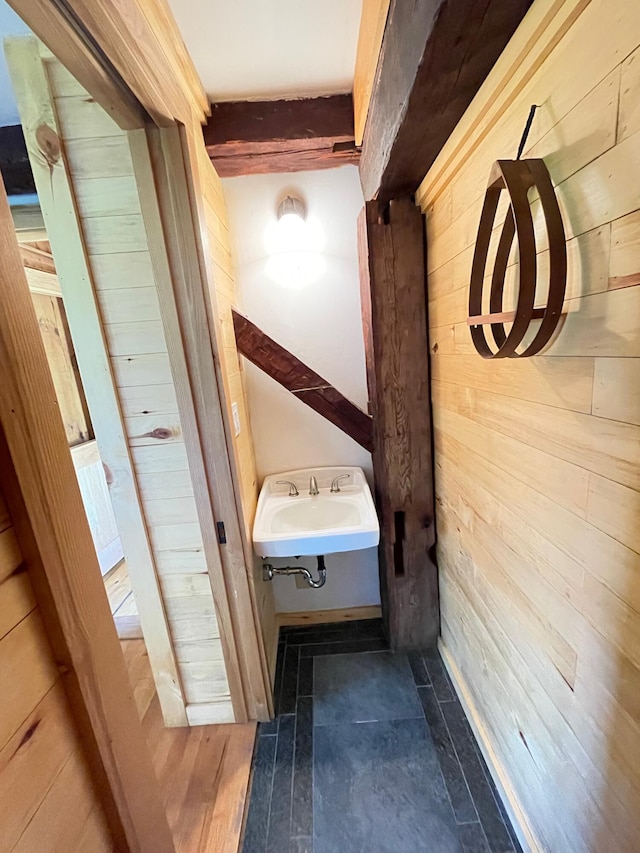 corridor featuring wood walls and a sink