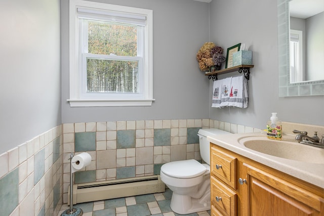 7 Canterbury Pines Dr, Gorham, ME 04038 - half bathroom with a baseboard heating unit, tile walls, toilet, vanity, and a wainscoted wall