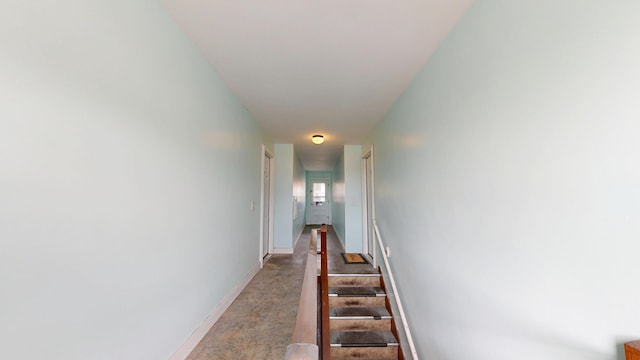 corridor featuring baseboards and stairs