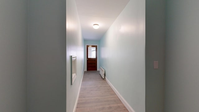 corridor with light wood finished floors and baseboards