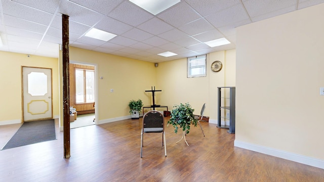 entrance foyer with wood finished floors, a drop ceiling, and baseboards