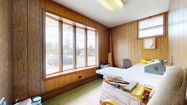 carpeted office space with a textured ceiling, wood walls, and baseboard heating