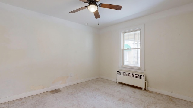 spare room featuring radiator, baseboards, and ceiling fan