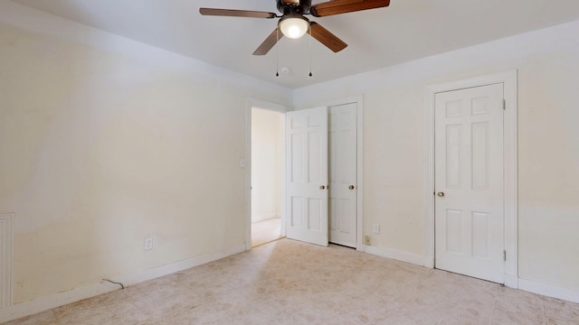 unfurnished bedroom with baseboards, two closets, and ceiling fan