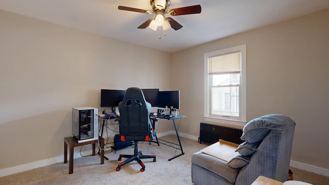 carpeted office space with baseboards, a ceiling fan, and radiator heating unit