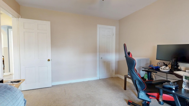 office area with carpet, baseboards, and arched walkways
