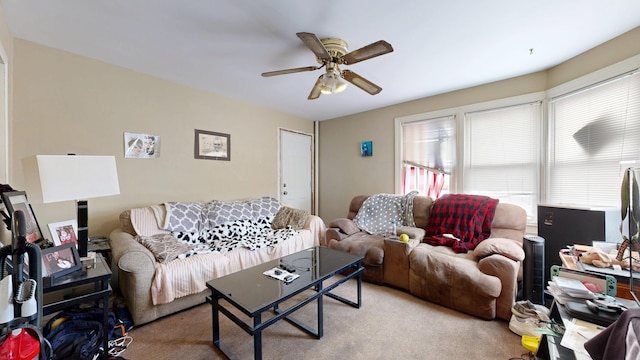 carpeted living area with a ceiling fan