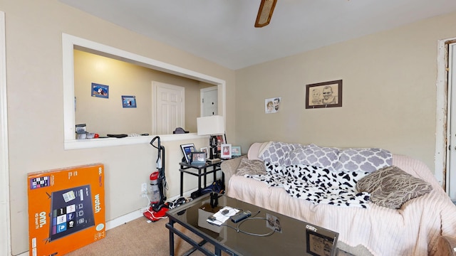 carpeted living area featuring a ceiling fan and baseboards