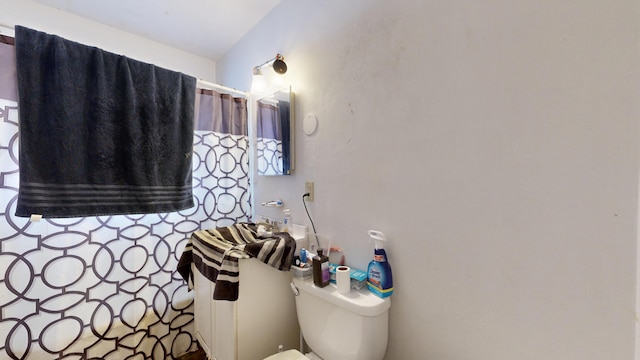 full bathroom with toilet and a shower with curtain