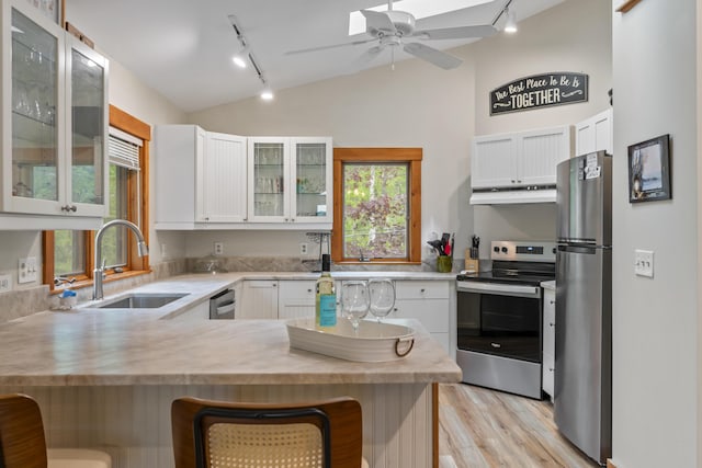 186 Ridge Rd, Frye Island, ME 04071 - kitchen with track lighting, stainless steel appliances, a sink, under cabinet range hood, and vaulted ceiling