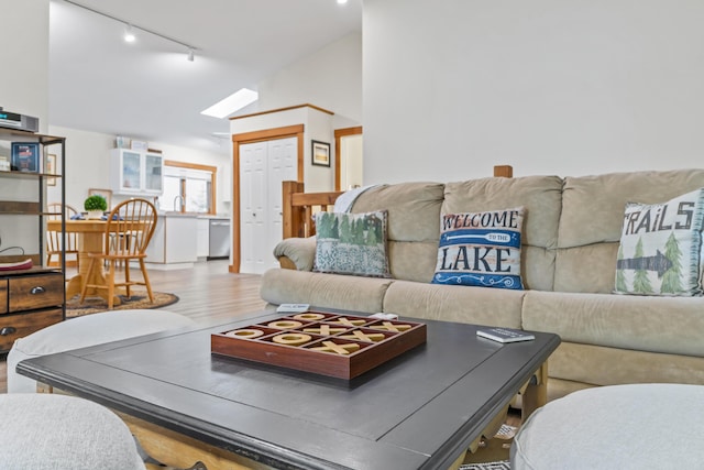 186 Ridge Rd, Frye Island, ME 04071 - living room with rail lighting, wood finished floors, and vaulted ceiling