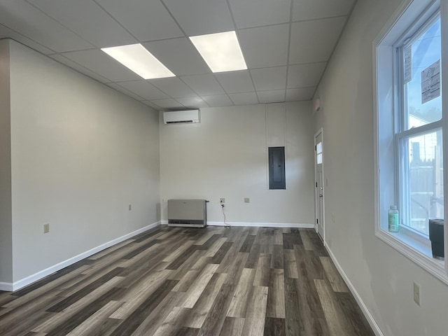 10 W Bates St, Auburn, ME 04210 - spare room with an AC wall unit, dark wood-type flooring, healthy amount of natural light, electric panel, and a paneled ceiling