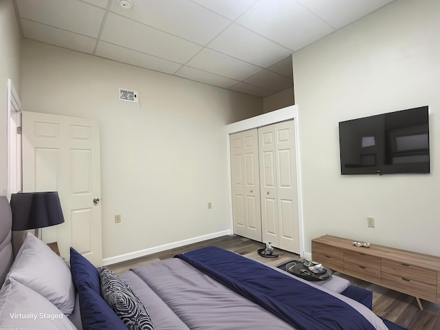 10 W Bates St, Auburn, ME 04210 - bedroom featuring a drop ceiling, dark wood-style flooring, a closet, and baseboards