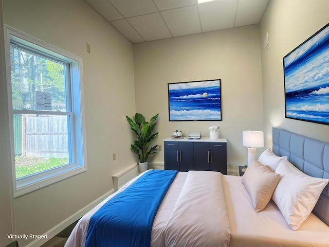 10 W Bates St, Auburn, ME 04210 - bedroom featuring a paneled ceiling, multiple windows, and baseboards