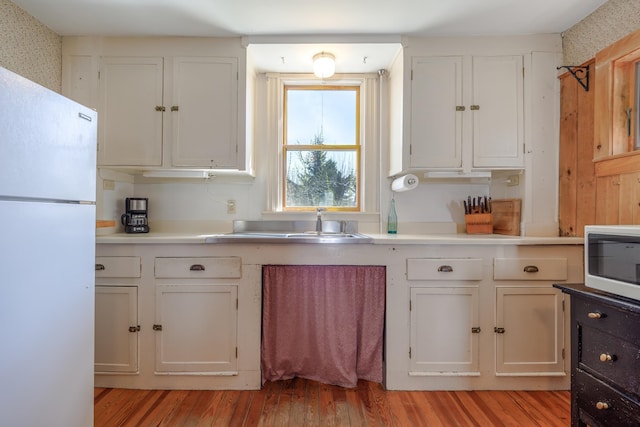 6 Sea St, Northeast Harbor, Mount Desert, ME 04662 - kitchen with white appliances, white cabinetry, a sink, light wood finished floors, and wallpapered walls