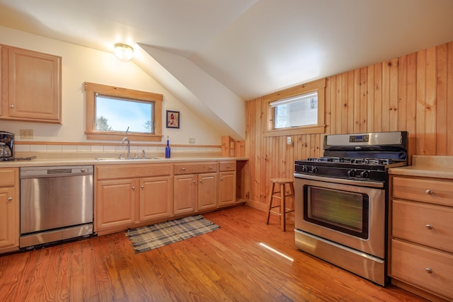 6 Sea St, Northeast Harbor, Mount Desert, ME 04662 - kitchen featuring appliances with stainless steel finishes, a sink, light wood-style floors, lofted ceiling, and wooden walls
