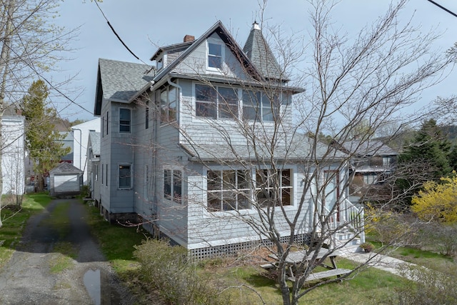 6 Sea St, Northeast Harbor, Mount Desert, ME 04662 - view of property exterior with asphalt driveway, roof with shingles, a garage, an outdoor structure, and a chimney