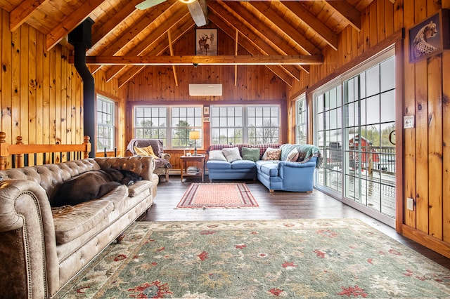 living area with beam ceiling, wood finished floors, wood walls, wooden ceiling, and an AC wall unit