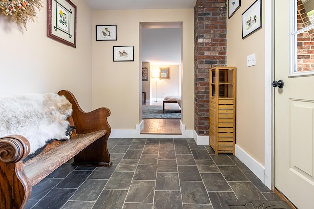 living area with baseboards and dark stone finish floors