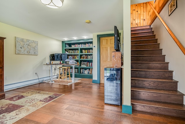 stairway featuring a baseboard radiator, hardwood / wood-style flooring, and wine cooler