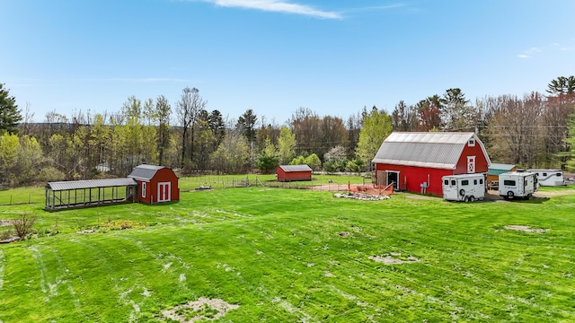 view of green lawn with an outdoor structure, a barn, and a shed
