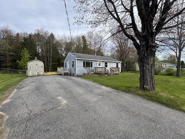 29 Faith St, Lisbon, ME 04252 - view of front of house featuring a shed, an outbuilding, driveway, a wooden deck, and a detached garage