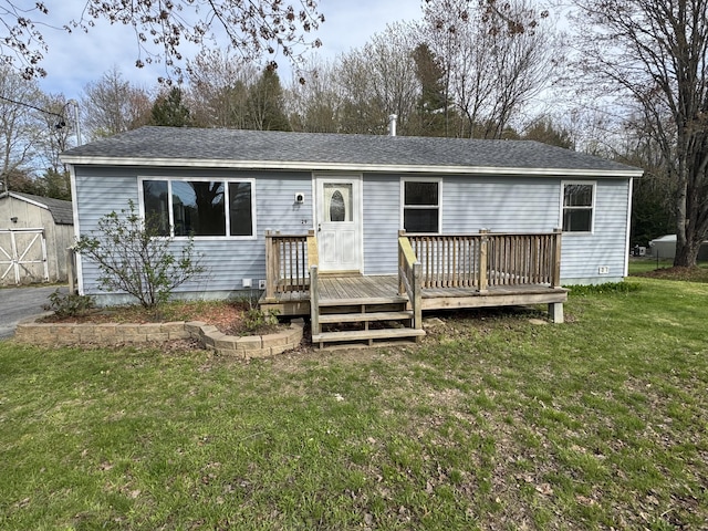 29 Faith St, Lisbon, ME 04252 - view of front of house with a deck, an outbuilding, a front lawn, and a shingled roof